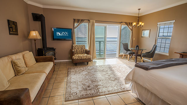 The Montara Room Sitting and Dining Area With Couch, Love Seat, Gas Stove and Dining Table