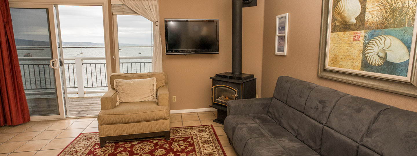Ross' Cove Guestroom Sitting Area With A Sofa, Love Seat, And Gas Stove