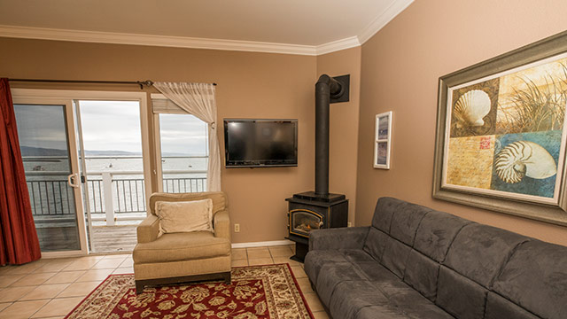 Ross' Cove Guestroom Sitting Area With A Sofa, Love Seat, And Gas Stove