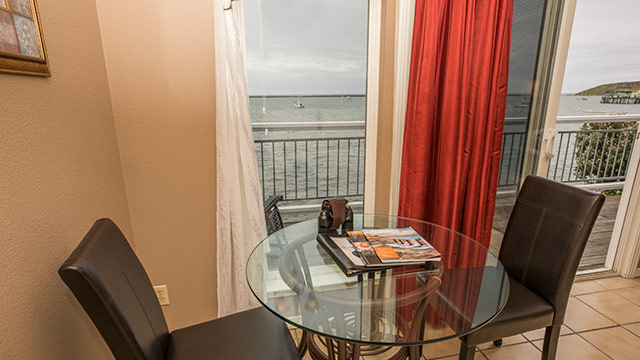 Ross' Cove Dining Area With Table And Ocean Views At Inn At Mavericks