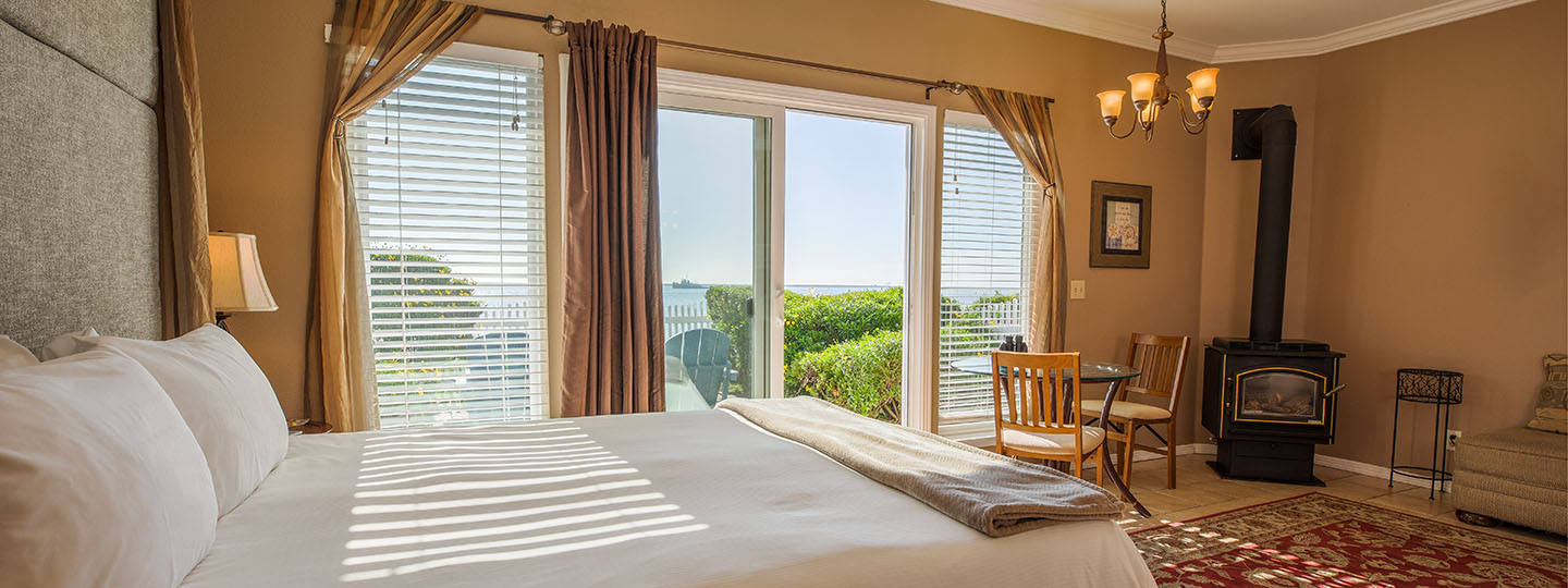 The Jetty Guestroom Bed and Dining Area With Gas Stove and Dining Table